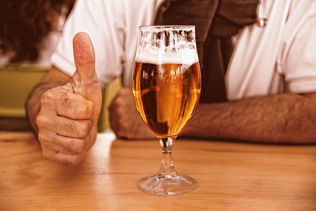 muž u stolu se sklenicí piva