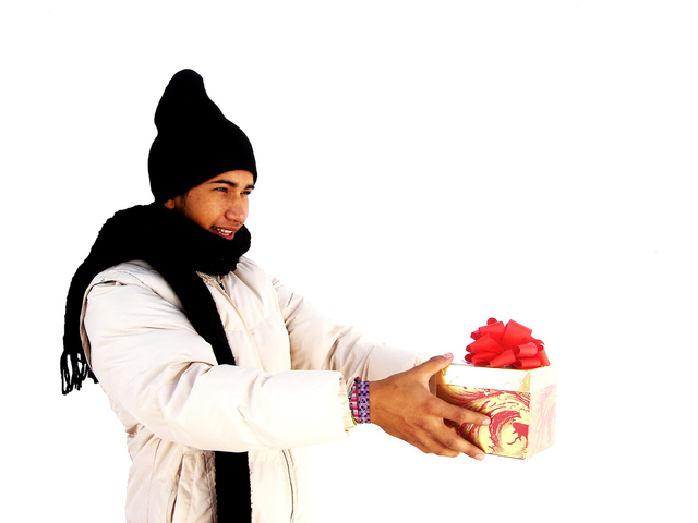 muž přijímající malý dárek v černé čepici a šále